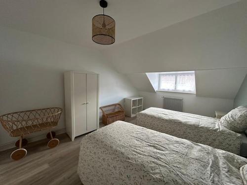 - une chambre avec deux lits, une armoire et une fenêtre dans l'établissement La petite Semuroise, à Semur-en-Auxois