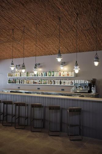 a bar with five bar stools in a room at Prinsotel La Pineda in Cala Ratjada
