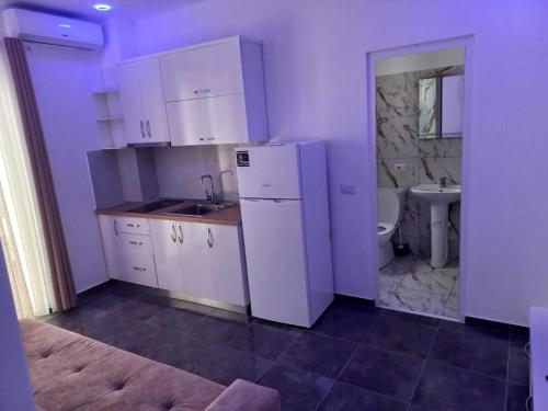 una cucina con frigorifero bianco e lavandino di Hotel Ersi a Shëngjin