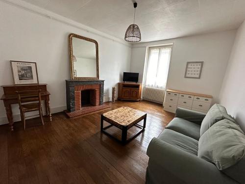 un salon avec un canapé et un miroir dans l'établissement La petite Semuroise, à Semur-en-Auxois