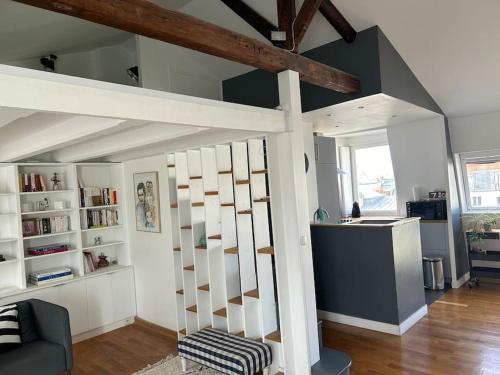 un salon avec une mezzanine avec un escalier dans l'établissement Appartement sur les toits de Paris vue Tour Eiffel 4 chambres, à Paris