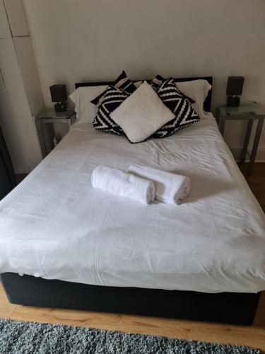 a white bed with two rolled towels on it at Regent Apartments - Glasgow City in Glasgow