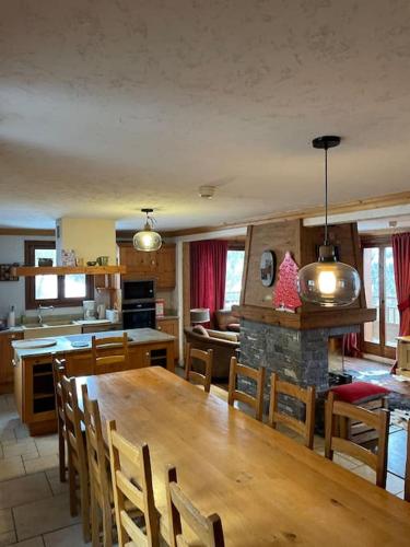 une cuisine et une salle à manger avec une grande table en bois dans l'établissement Chalet 6 chambres à 3 min des pistes des 3 Vallées st martin de Belleville, à Béranger