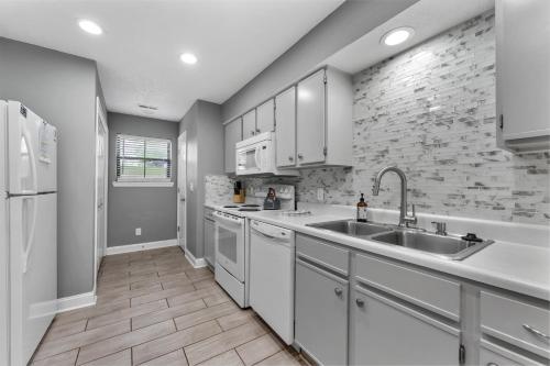 a kitchen with white cabinets and a sink at Free Daily Attractions including Silver Dollar City! Spacious, Centrally located, 2 pools in Branson