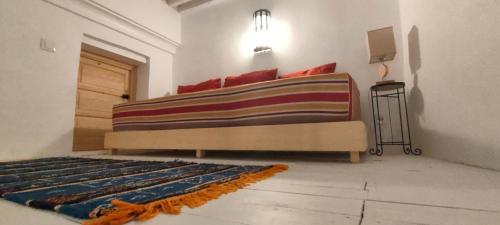 a bedroom with a bed with a colorful blanket on it at La Maison des Amis in Fès