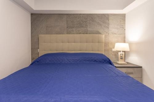 a bedroom with a blue bed and a lamp at Residenza Botticelli in Lecce