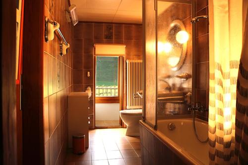 uma casa de banho com um lavatório, um WC e uma janela. em Au Cheval Blanc em Asuel