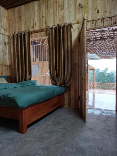 a wooden room with a bed with a window at Hill House in Mai Chau