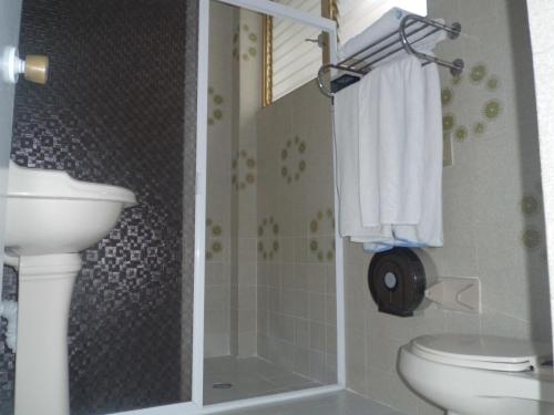 a bathroom with a shower and a toilet and a sink at Suites Angelopolis in Acapulco