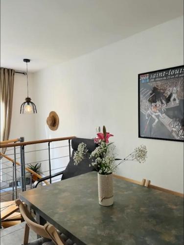 un salon avec une table avec un vase de fleurs dessus dans l'établissement Maison Mèze, à Mèze
