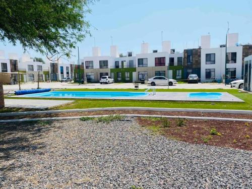 um parque de estacionamento com duas piscinas em frente a um edifício em Cómoda Casa cerca de Soledad-Aeropuerto em San Luis Potosí