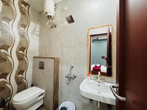 a bathroom with a sink and a toilet and a mirror at Home Escape 2BHK Apartment Near Brilliant Convention Centre in Indore