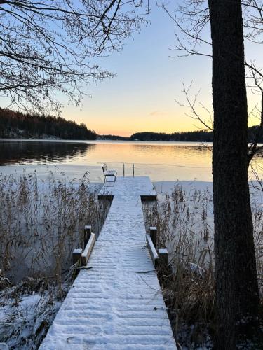 a dock in the middle of a lake with snow at Sauna cabin in the heart of Nuuksio National Park - Mökki Nuuksiossa in Espoo