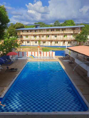 a large swimming pool in front of a hotel at Hotel santa marta Melgar in Melgar