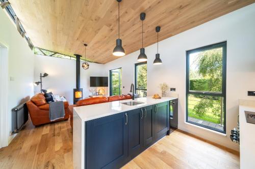 a kitchen with blue cabinets and a living room with a couch at Rowanbank Cabin - a gorgeous country escape in Kirkton of Auchterhouse