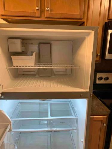 an empty refrigerator with its door open in a kitchen at Stay Awhile in Charlotte