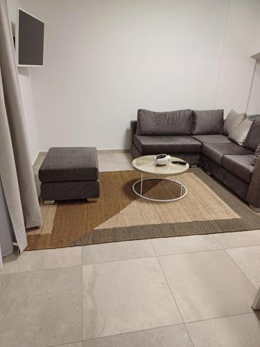 a living room with a couch and a coffee table at TEGEA LUXURY SUITES Athena in Tripolis