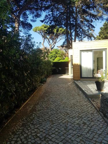 a brick walkway next to a white building with trees at 205 Serenity in Cascais