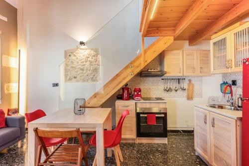 a kitchen with a wooden table and red chairs at Arcade central retro apartment in Rethymno