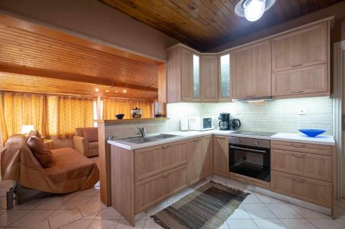 una cocina con armarios de madera y fregadero en Relax view, en Kalívia Thorikoú
