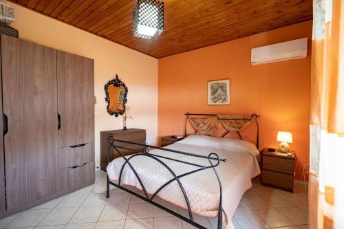 1 dormitorio con cama y pared de color naranja en Relax view, en Kalívia Thorikoú