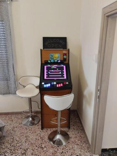 a video game machine with two stools in a room at Arcade central retro apartment in Rethymno Town