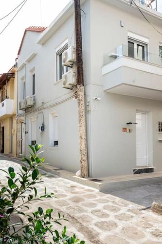 an empty street with a white building at Arcade central retro apartment in Rethymno Town
