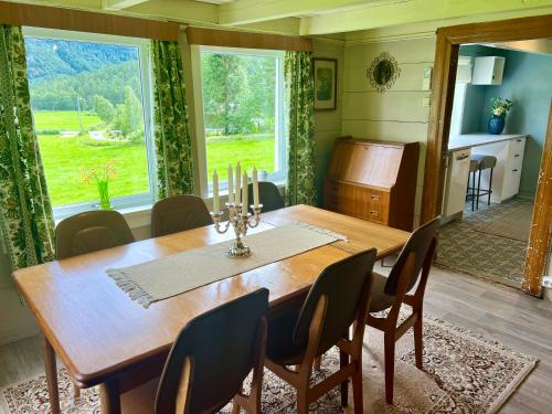 uma sala de jantar com uma mesa de madeira e cadeiras em Koselig feriehus sentralt i Sirdal em Tjørhom