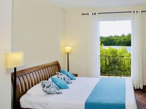 1 dormitorio con cama y ventana grande en Cozy 2-bedroom villa on river mouth en Terre Rouge