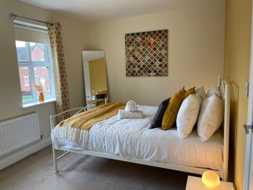 a bedroom with a bed with pillows on it at Fleetwood - 3 bedroom apartment, fab 4 contractors in Gateshead