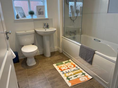 a bathroom with a toilet and a sink and a shower at Fleetwood - 3 bedroom apartment, fab 4 contractors in Gateshead