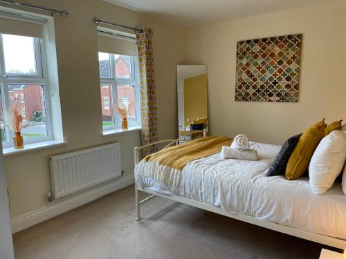 a bedroom with a bed and two windows at Fleetwood - 3 bedroom apartment, fab 4 contractors in Gateshead