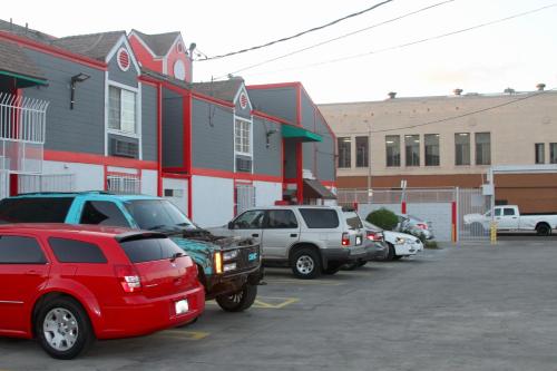 a parking lot with cars parked in front of a building at Broadway Inn Motel in Los Angeles