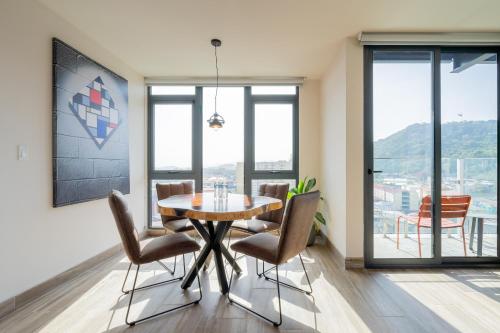 a dining room with a table and chairs and windows at Casco View By Wynwood House in Panama City