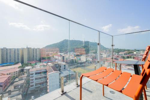 a balcony with orange chairs and a view of a city at Casco View By Wynwood House in Panama City