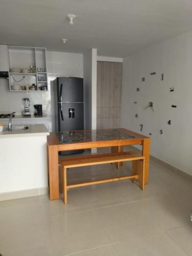 a kitchen with a wooden table and a refrigerator at la aldea relax in Ricaurte