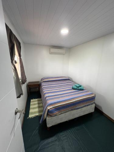 a small bedroom with a bed in a room at Cabañas El Calabres in Tacuarembó