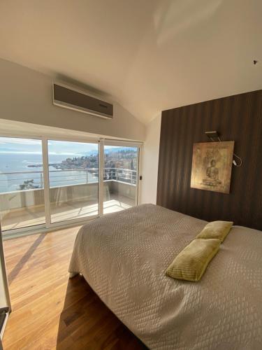 a bedroom with a large bed and a large window at Villa Dinka VIP apartmani in Opatija