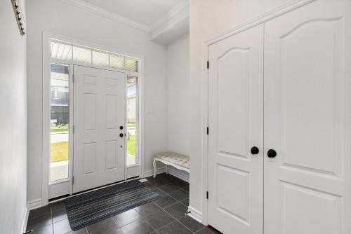 pasillo con puertas blancas y ventana en Fully Furnished 4 Bedroom House in Ottawa, en Ottawa