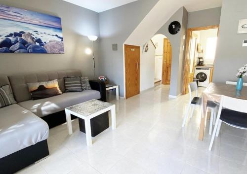 ein Wohnzimmer mit Sofa und Tisch in der Unterkunft Imperial Park - Bungalow 3503 in Calpe