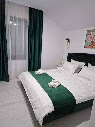 una camera da letto con un grande letto con asciugamani di Gold Tag Apartament a Timişoara
