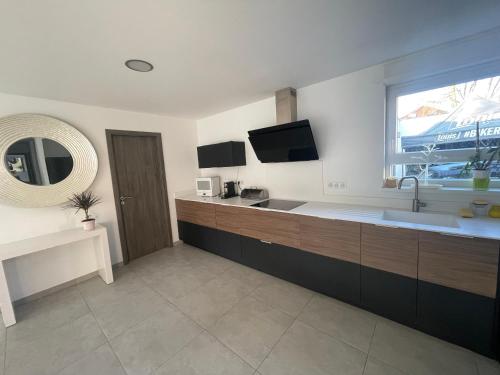 eine große Küche mit einem Waschbecken und einem Fenster in der Unterkunft Villa plein pied in Lingolsheim