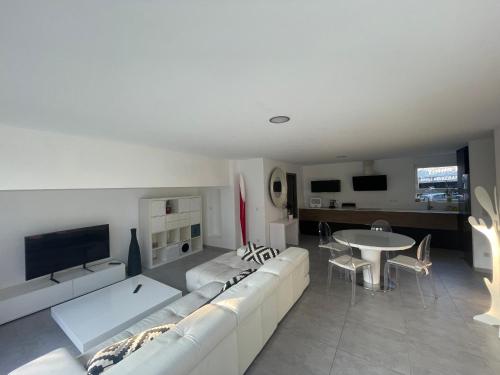 uma sala de estar com um sofá branco e uma mesa em Villa plein pied em Lingolsheim