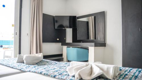 a bedroom with a bed with a mirror and a tv at HOTEL KAISER in Sousse