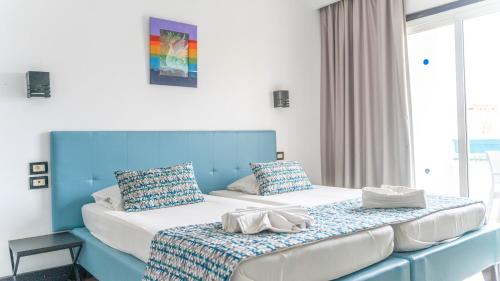 two beds in a room with blue and white at HOTEL KAISER in Sousse