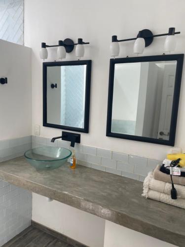 ein Bad mit einem Waschbecken und 2 Spiegeln in der Unterkunft Puerta Negra in Playa Flamingo