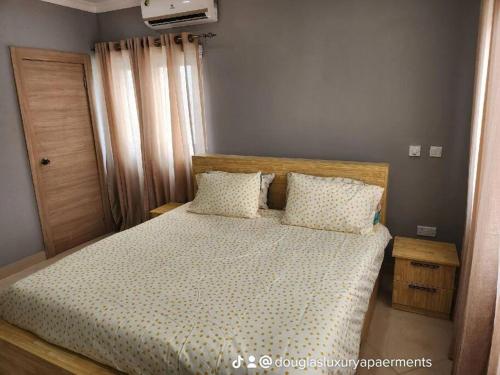 een slaapkamer met een bed met witte lakens en kussens bij Commander Place Accra-Urban Budget Living 1,2-Beds in Oyarifa, Wifi, 5star service, 35mins to airport, by DLA in Oyarifa