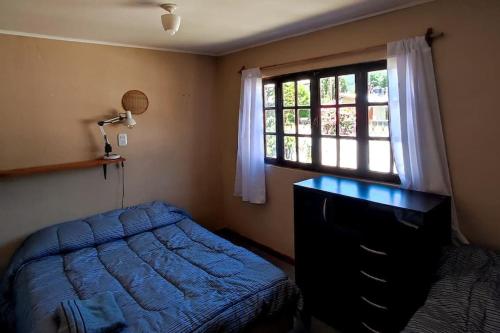 a bedroom with a blue bed and a window at Departamento en el centro in Lago Puelo