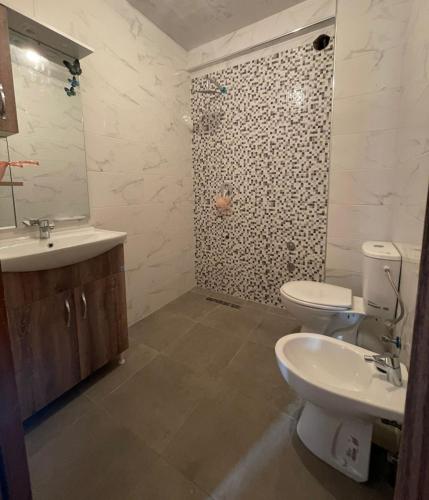 y baño con aseo, lavabo y ducha. en Magnifique appartement à Bouznika en Bouznika