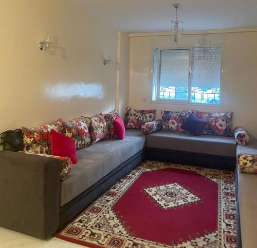 sala de estar con sofá y alfombra roja en Magnifique appartement à Bouznika en Bouznika